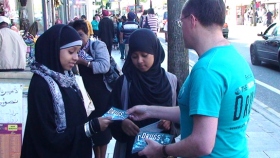 ロンドンの大通りを歩く若者や大人に薬物乱用防止教育の小冊子が配布されています。